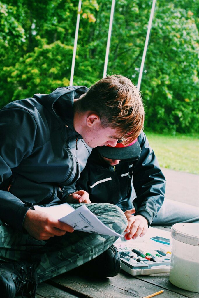 Students studying chemistry materials together, focused on textbooks and lab equipment.