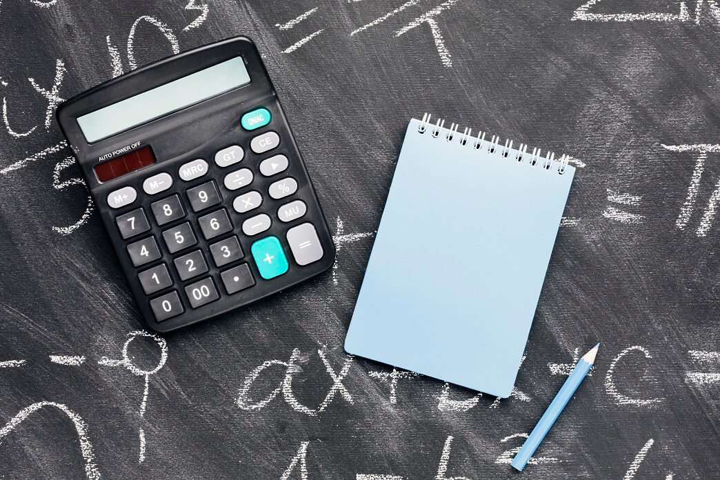 calculator and a notebook on a chalkboard